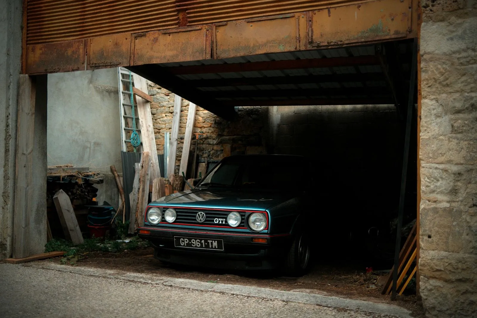 Voiture ancienne sous housse dans un garage, clés posées sur une étagère, ambiance calme
